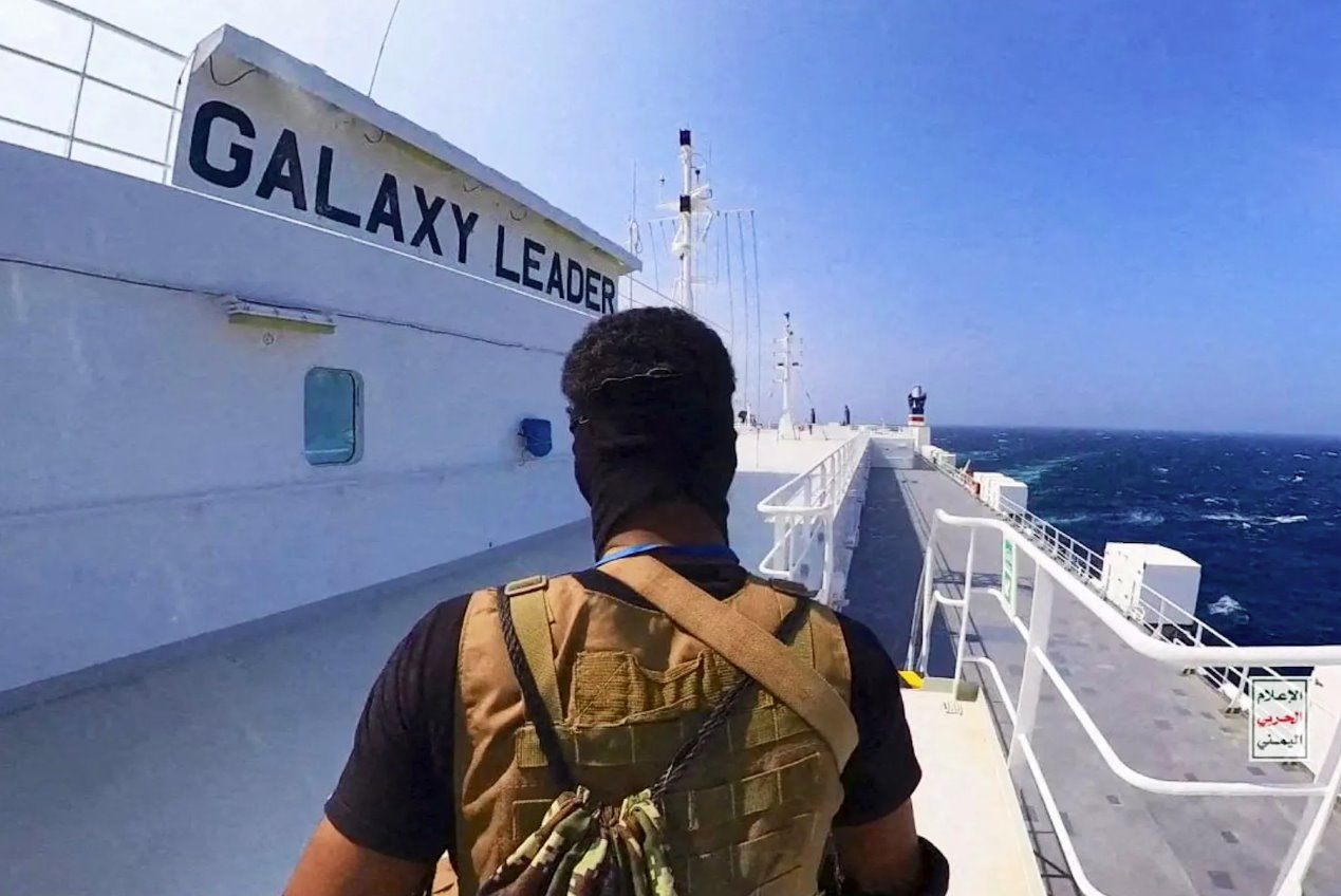 2023年11月20日發(fā)布的這張照片中,一名胡塞戰(zhàn)士站在紅海的銀河領(lǐng)袖號(hào)貨船上。