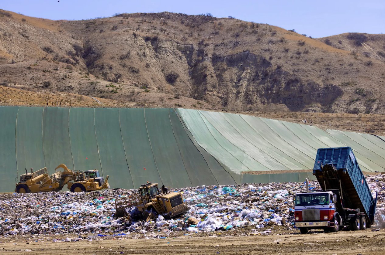 2021年6月15日，美國(guó)加利福尼亞州歐文市的FrankR.Bowerman垃圾填埋場(chǎng)，工人們使用重型機(jī)械搬運(yùn)垃圾和廢物。