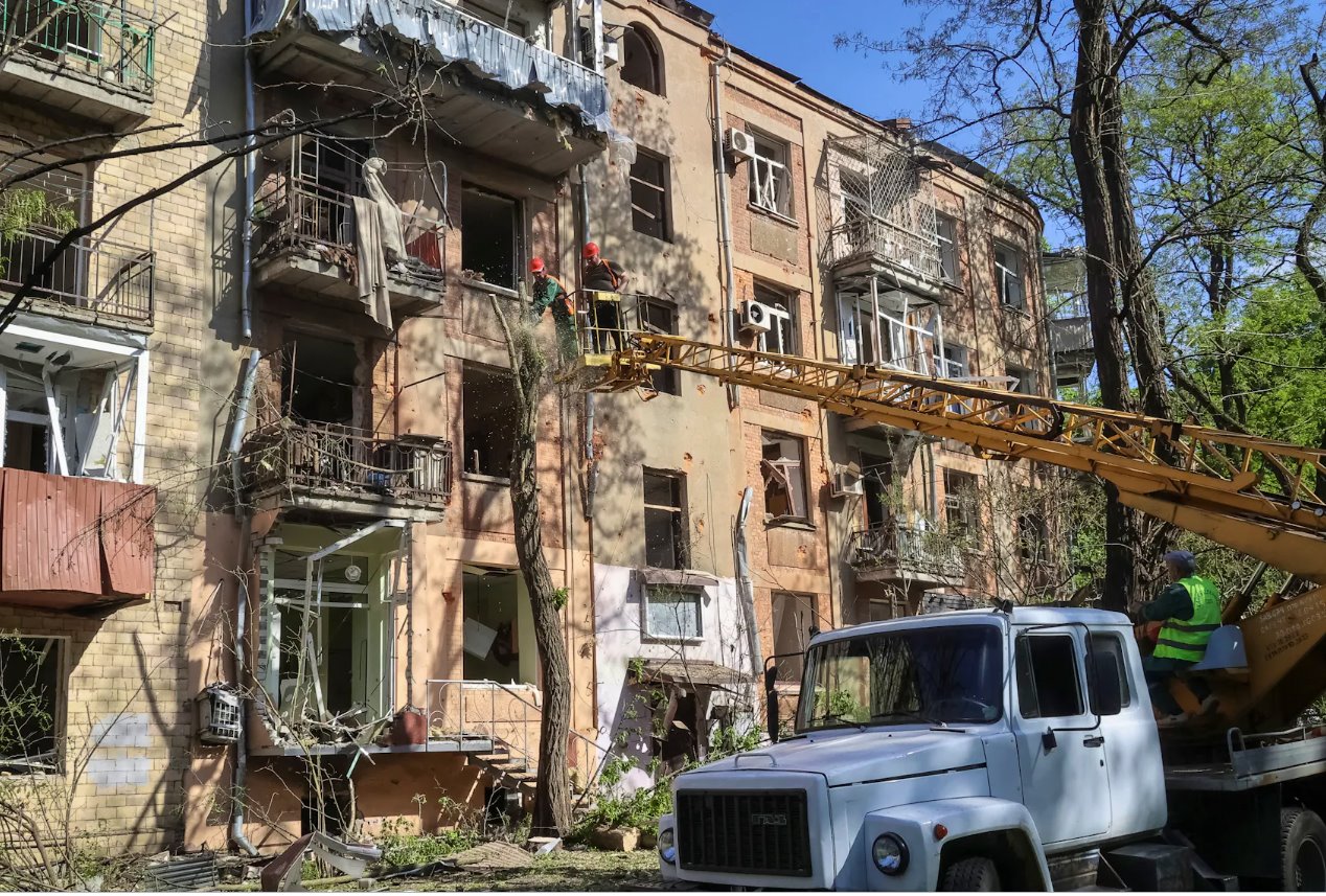 2024年5月5日，烏克蘭哈爾科夫，社區(qū)工作人員在烏克蘭哈爾科夫一棟因俄羅斯空襲而受損的公寓樓附近的工地工作。