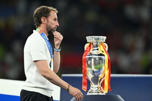 索斯蓋特經(jīng)過2024年歐洲杯獎(jiǎng)杯旁邊