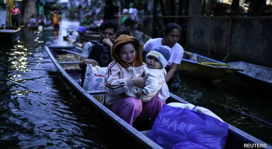 菲律賓熱帶風暴博羅依加劇降雨，民眾乘船過馬路
