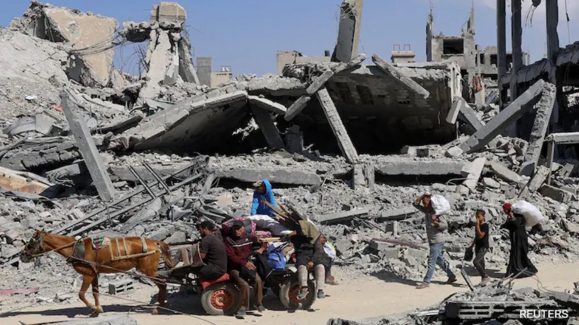 以色列與哈馬斯達(dá)成?；饏f(xié)議后，巴勒斯坦人在以色列軍隊(duì)撤離后走過(guò)廢墟