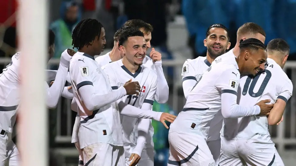 瑞士隊在2026年世界杯預(yù)選賽中保持不敗，戰(zhàn)績?yōu)樗膭賰善健? /></p>
<p>溫州網(wǎng)體育新聞，瑞士隊以不敗戰(zhàn)績鎖定2026年世界杯參賽資格，在普里什蒂納頂住了科索沃隊的最后反撲，最終與對手戰(zhàn)平。</p>
<p>上半場雙方表現(xiàn)平平，第47分鐘，魯本&middot;巴爾加斯接應(yīng)吉布里爾&middot;索烏的精準(zhǔn)傳球，從后場溜入禁區(qū)，將球送入科索沃門將阿里賈內(nèi)特&middot;穆里奇把守的球門。</p>
<p>但弗洛倫特&middot;穆斯利亞在第74分鐘以一記精彩的弧線球射門將球送入球門右上角，扳平了比分。</p>
<p>主隊在比賽尾聲階段全力爭取制勝，巴頓&middot;扎貝里賈和韋達(dá)特&middot;穆里奇的射門都被門將格雷戈爾&middot;科貝爾撲出。</p>
<p>瑞士隊需要贏球或打平才能自動獲得明年比賽的參賽資格，而科索沃隊即使贏球也可能不夠，因為瑞士隊的凈勝球優(yōu)勢非常明顯。</p>
<p>這一結(jié)果意味著瑞士隊以14分位列B組榜首，而力爭首次晉級世界杯的科索沃隊以11分位列第二，并將參加3月份的歐洲區(qū)附加賽。</p>　　本文“世預(yù)賽足球新聞”來源：http://www.zjjzhonglv.com/sports/7384.html，轉(zhuǎn)載必須保留網(wǎng)址。
      <div   id=