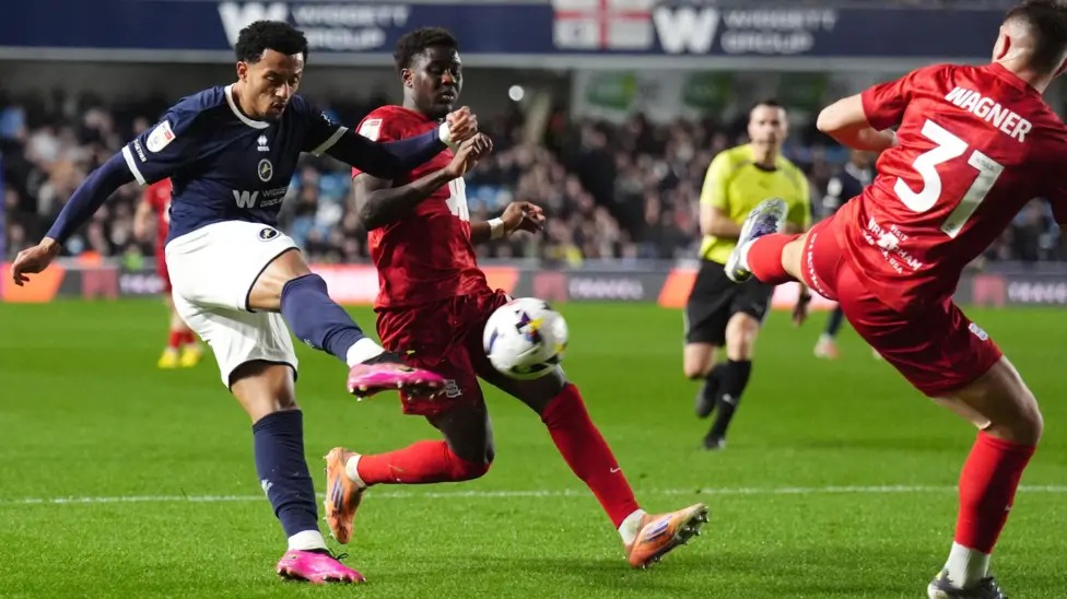 米爾沃爾隊(duì)的費(fèi)米&middot;阿齊茲凌空抽射，伯明翰隊(duì)的凱&middot;瓦格納抬腳試圖封堵射門(mén)。